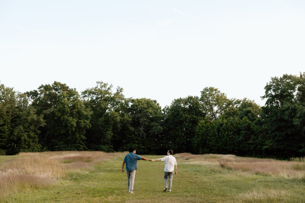 Couple walking through a meadow.