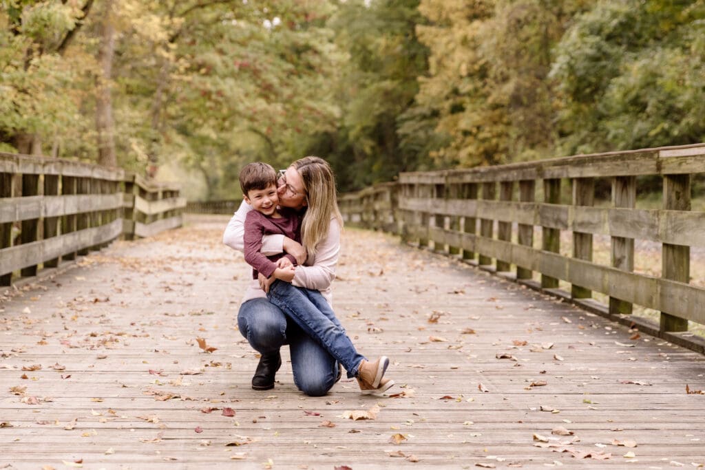 Mom kissing son on the cheek.