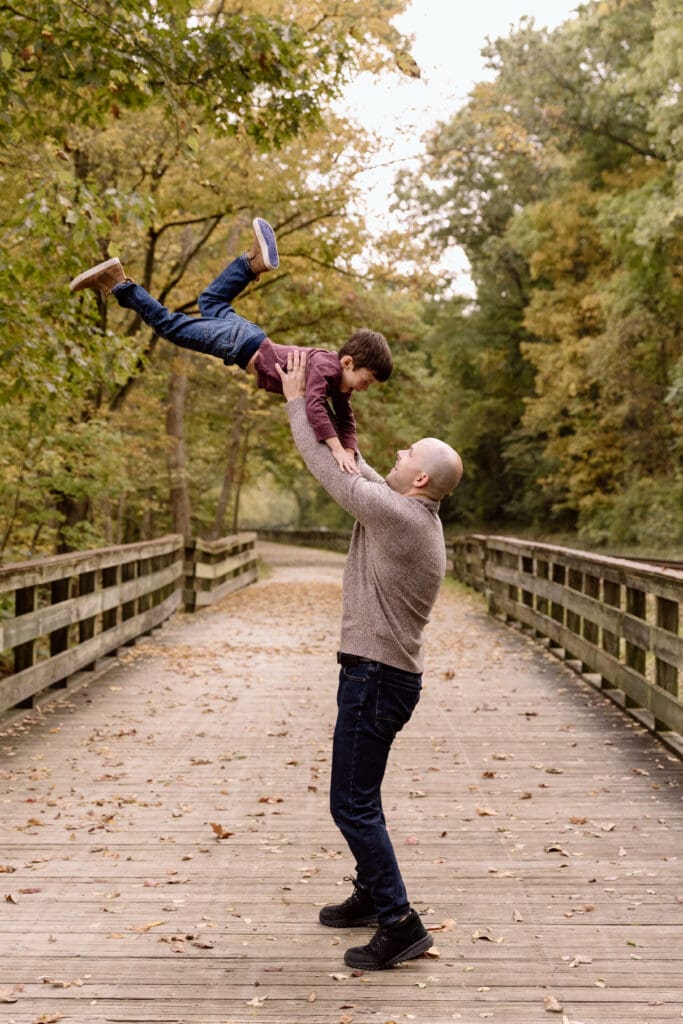 Dad lifting son in the air.