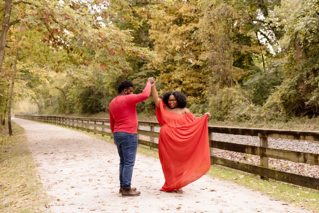 Husband spinning his wife in a park.